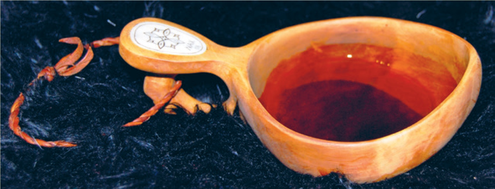 Guksi. Kaffekopp av rikule i bruk. Eierens initialer er inngravert. Foto: Samisk arkiv / Sámi Arkiiva