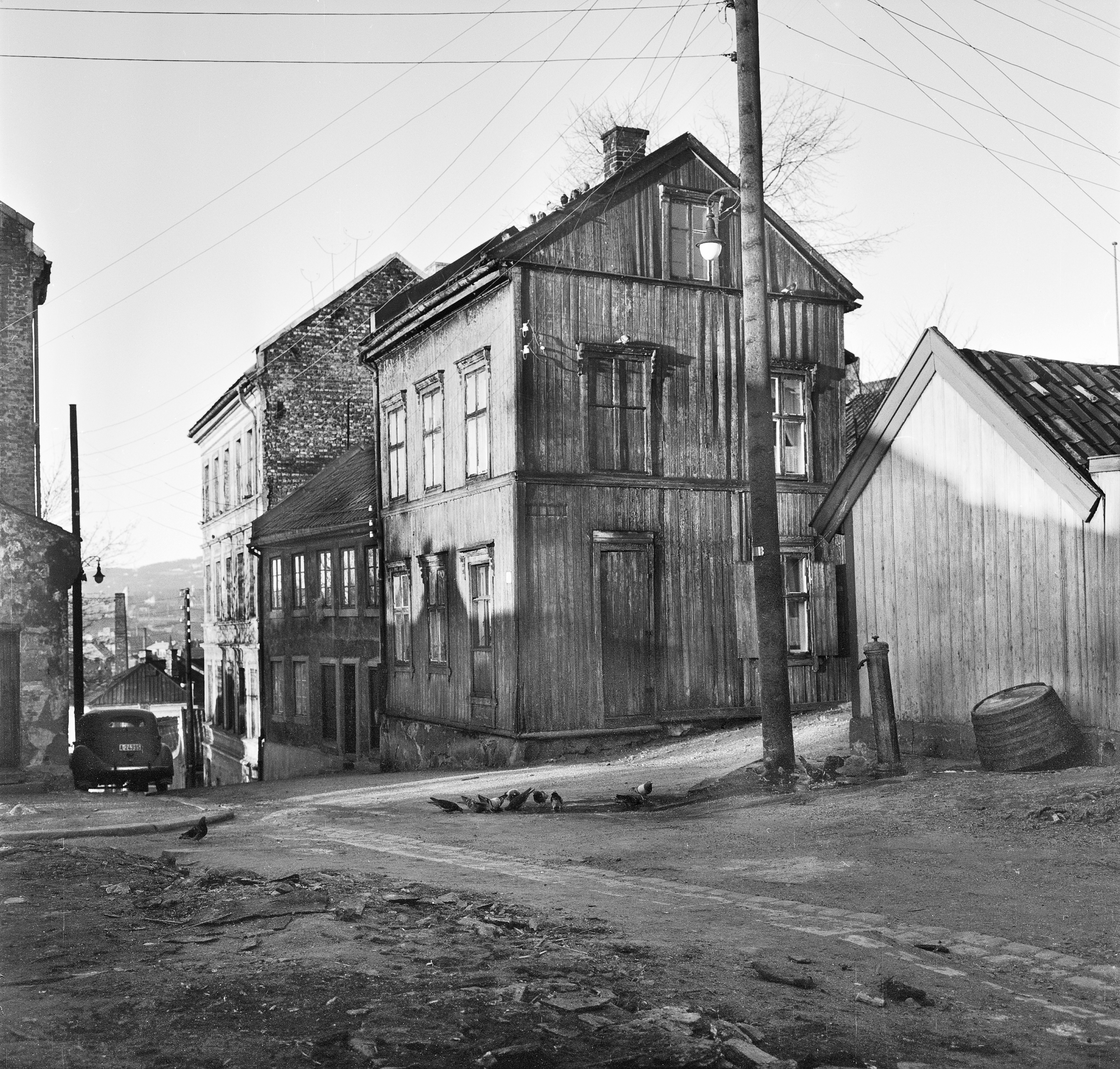 Trehusbebyggelse med vannpost på Enerhaugen, krysset Langleiken og Johannesgata i 1959. Foto: Peter Anker, Oslo Museum OB.A1088.